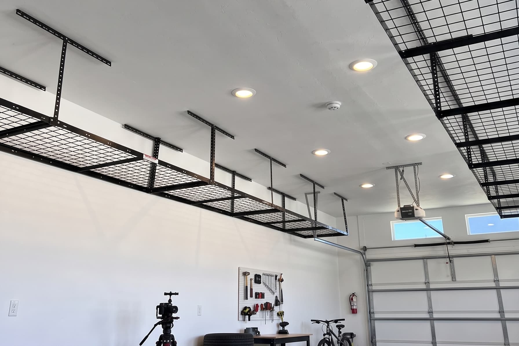 Black overhead storage racks installed in a garage